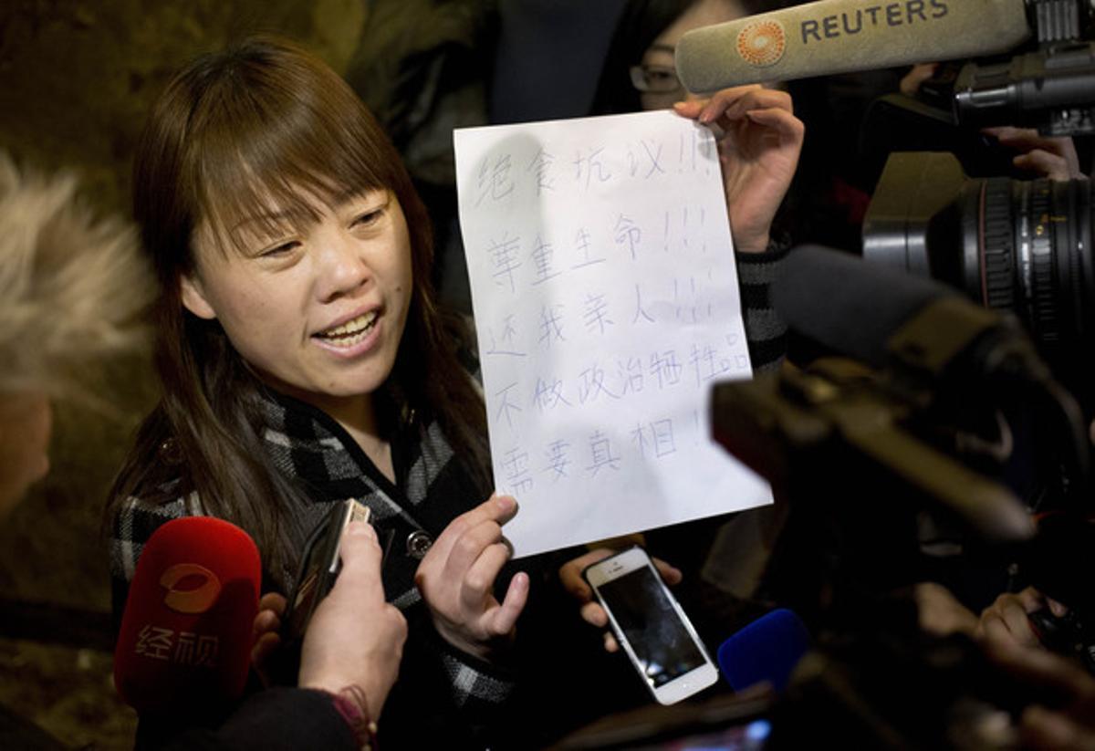 Una familiar d’un passatger del vol MH370 mostra als periodistes un paper en què s’anuncia una vaga de fam i es demana a les autoritats que diguin la veritat, aquest dimarts a Pequín. Una familiar d’un passatger del vol MH370 mostra als periodistes un paper en què s’anuncia una vaga de fam i es demana a les autoritats que diguin la veritat, aquest dimarts a Pequín.