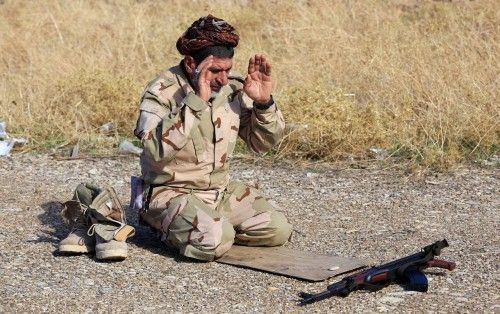 Un soldado chiíta iraquí reza en la línea de frente contra el Estado islámico, Las fuerzas iraquíes dijeron el domingo que retomaron dos ciudades al norte de Bagdad expulsando a las fuerzas del Estado islámico. 23 de noviembre de 2014.
