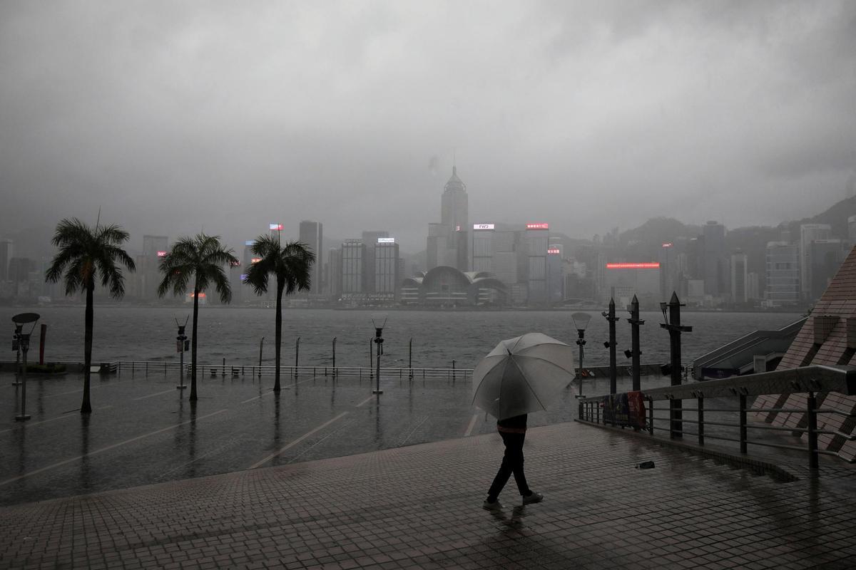 Un ciudadano con un paraguas camina por las calles de Hong Kong durante una lluvia torrencial causada por un tifón.