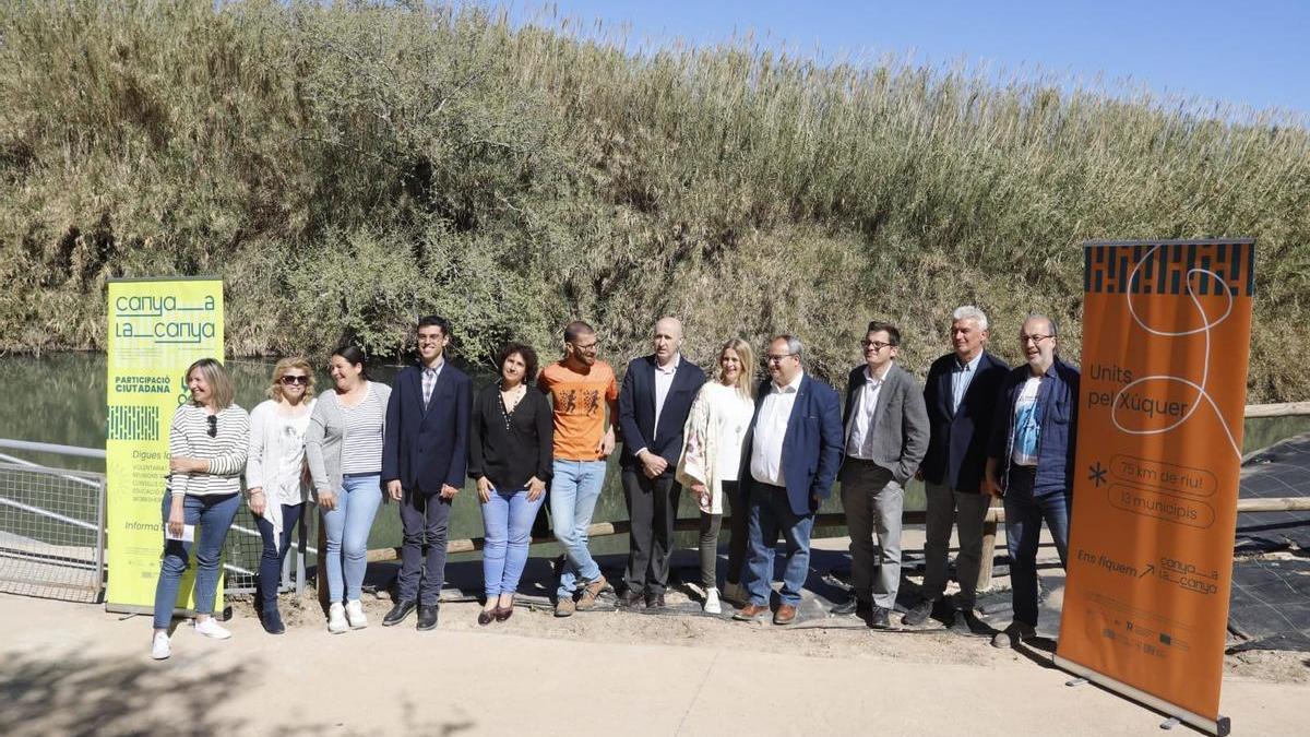 Las autoridades, con las cañas del río al fondo, en el acto celebrado esta mañana en Alzira.