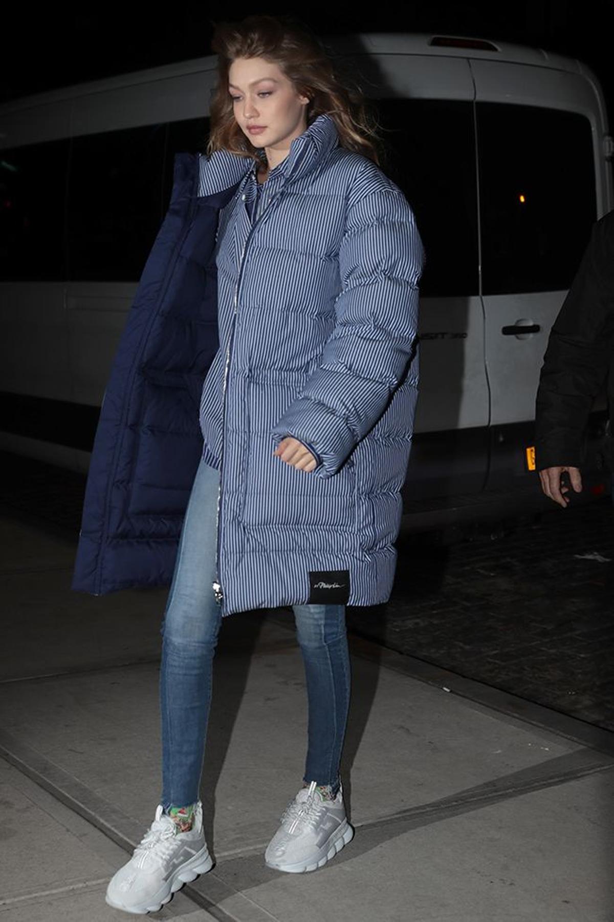 Gigi Hadid con plumífero, camisa, vaqueros y 'chunky sneakers' por la calle
