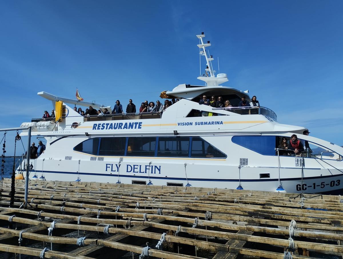 El &quot;Fly Delfín&quot; abarloado a una batea para explicar cómo se realiza el cultivo de mejillón y ostra, ayer.