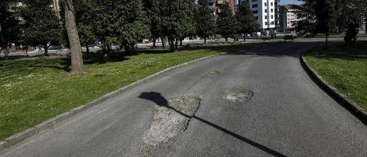 Dos grandes baches en medio de la calzada junto a la plaza.