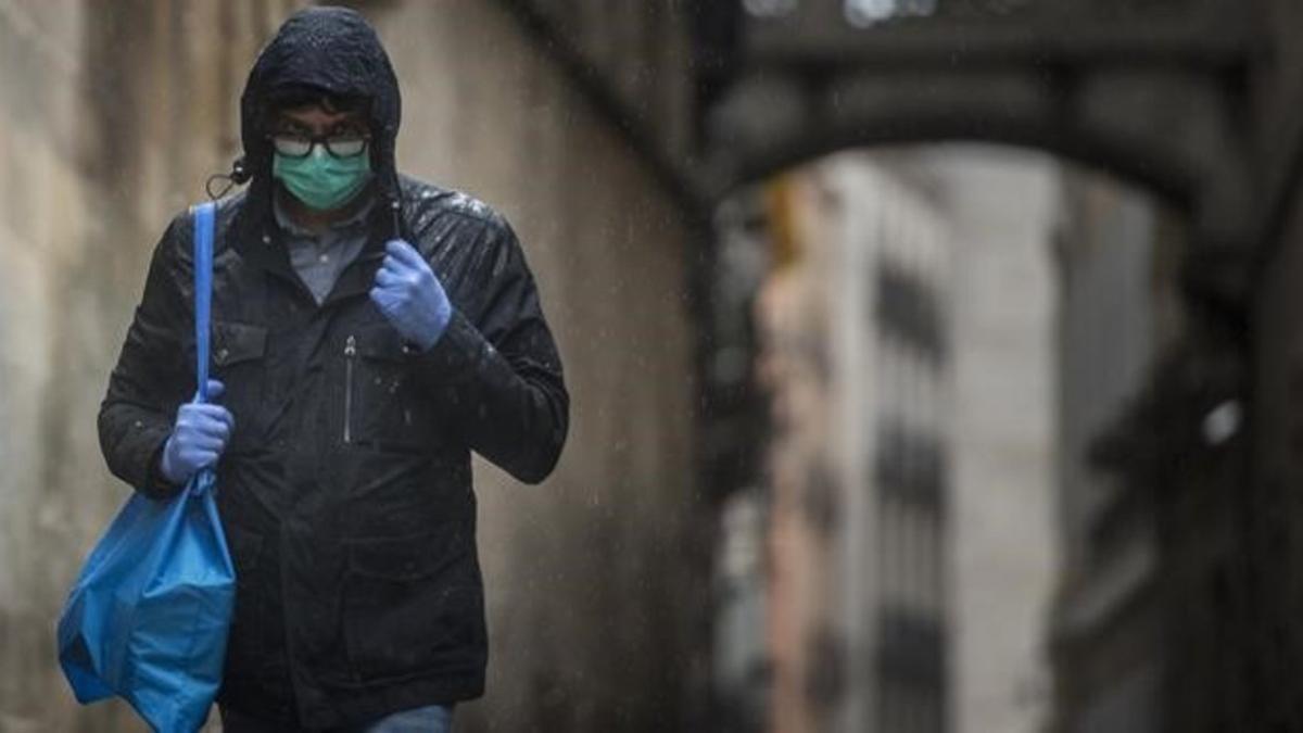 16 03 2020  BarcelonaUn transeunte con mascarilla y guantes camina por la calle del Bisbe  por prevencion debido al coronavirus.