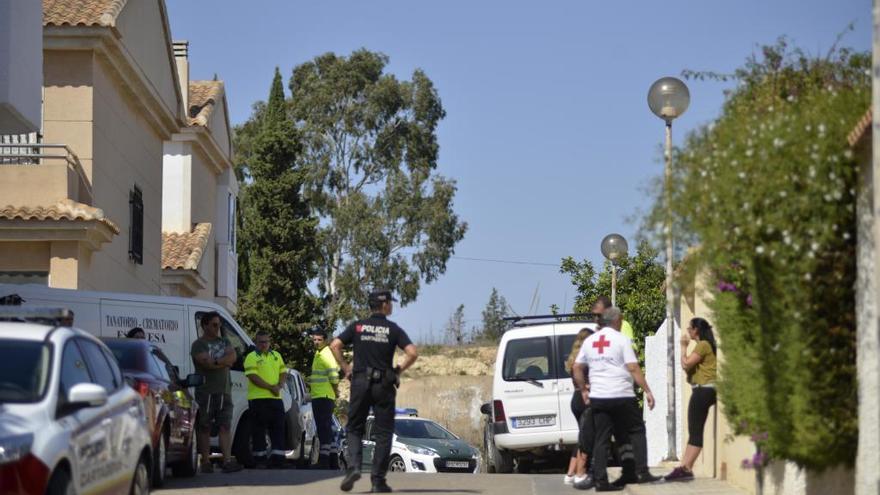 El furgón fúnebre aguarda en el lugar de los hechos para recoger el cuerpo de la víctima