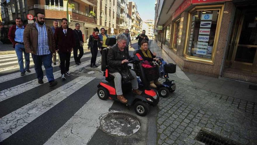 Dos personas en silla de ruedas intentan salvar los escollos en el cruce de Castor Sánchez con Juan Carlos I. // Iñaki Abella