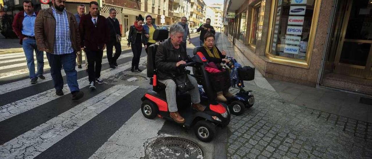 Dos personas en silla de ruedas intentan salvar los escollos en el cruce de Castor Sánchez con Juan Carlos I. // Iñaki Abella