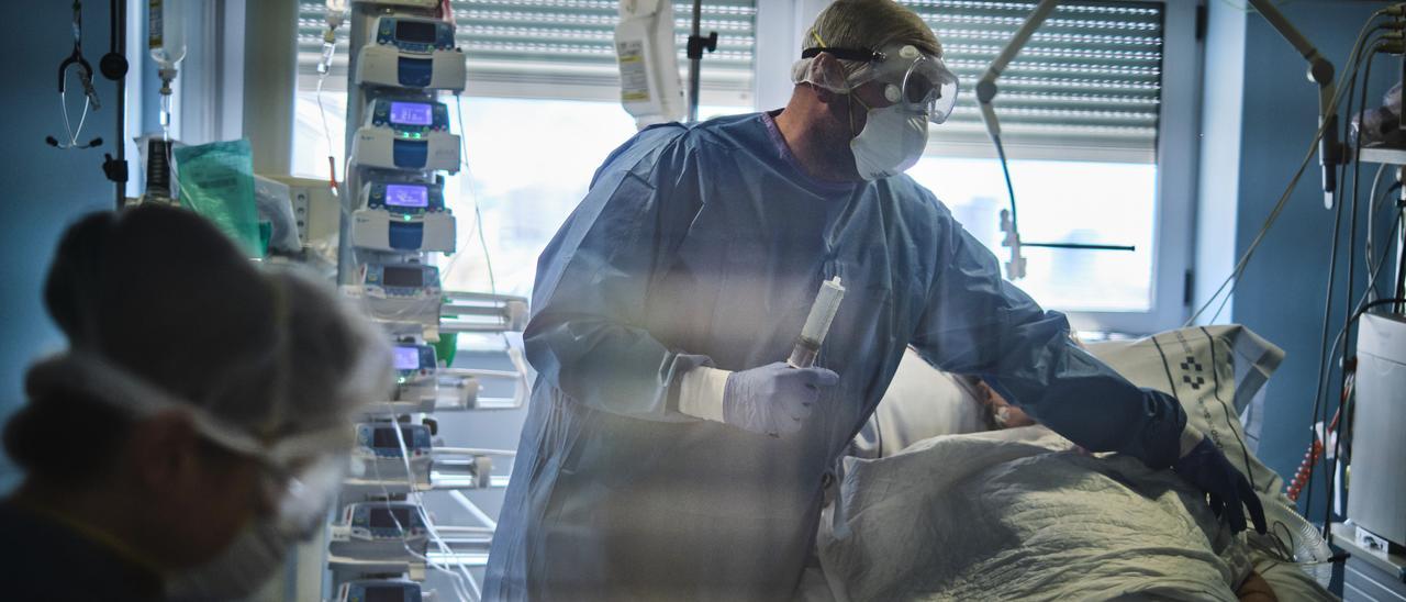 Un sanitario trata a un paciente con covid en la UCI del Hospital de La Candelaria.