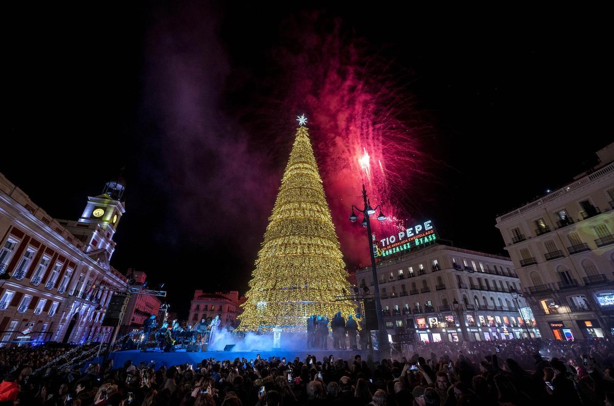 Árbol de navidad situado en la Puerta del Sol con fuegos artificiales de fondo