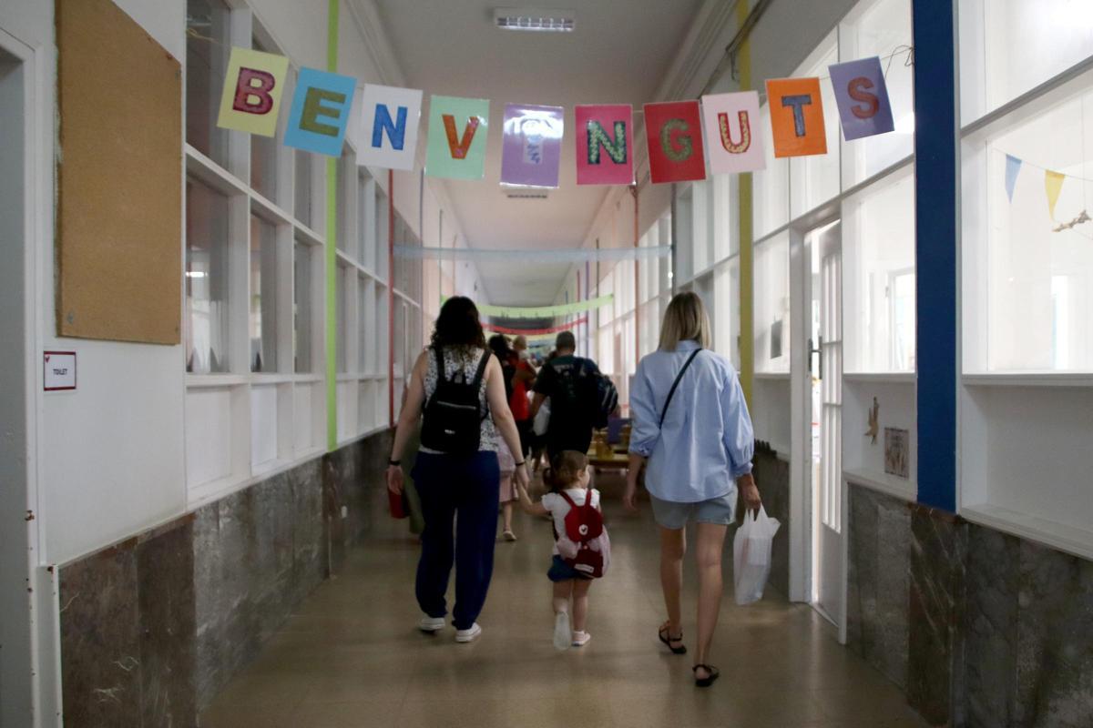 Infants amb les seves famílies el primer dia de curs entrant en un centre educatiu