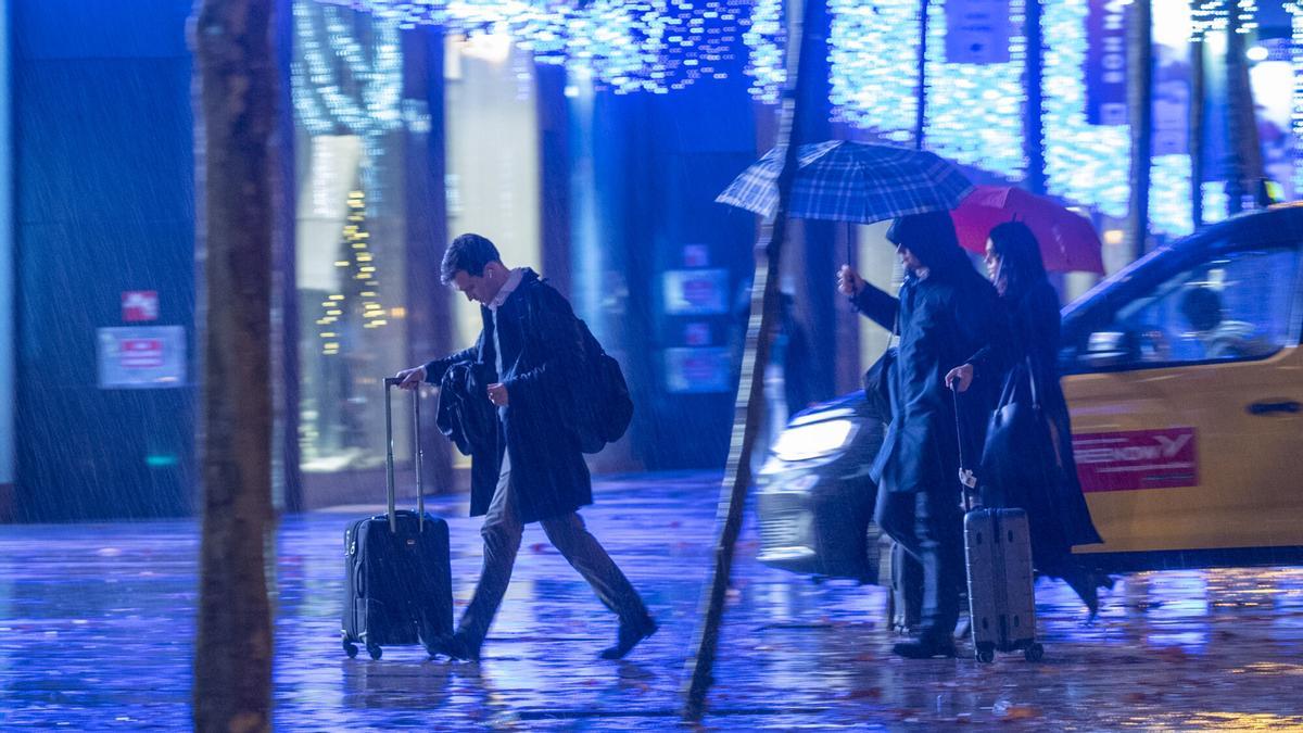 Una persona que baja del taxi y se encuentra con lluvias intensas en Barcelona