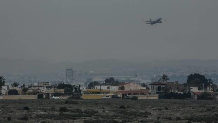 Un avión despegando del aeropuerto Alicante-Elche sobre una agrupación de viviendas.