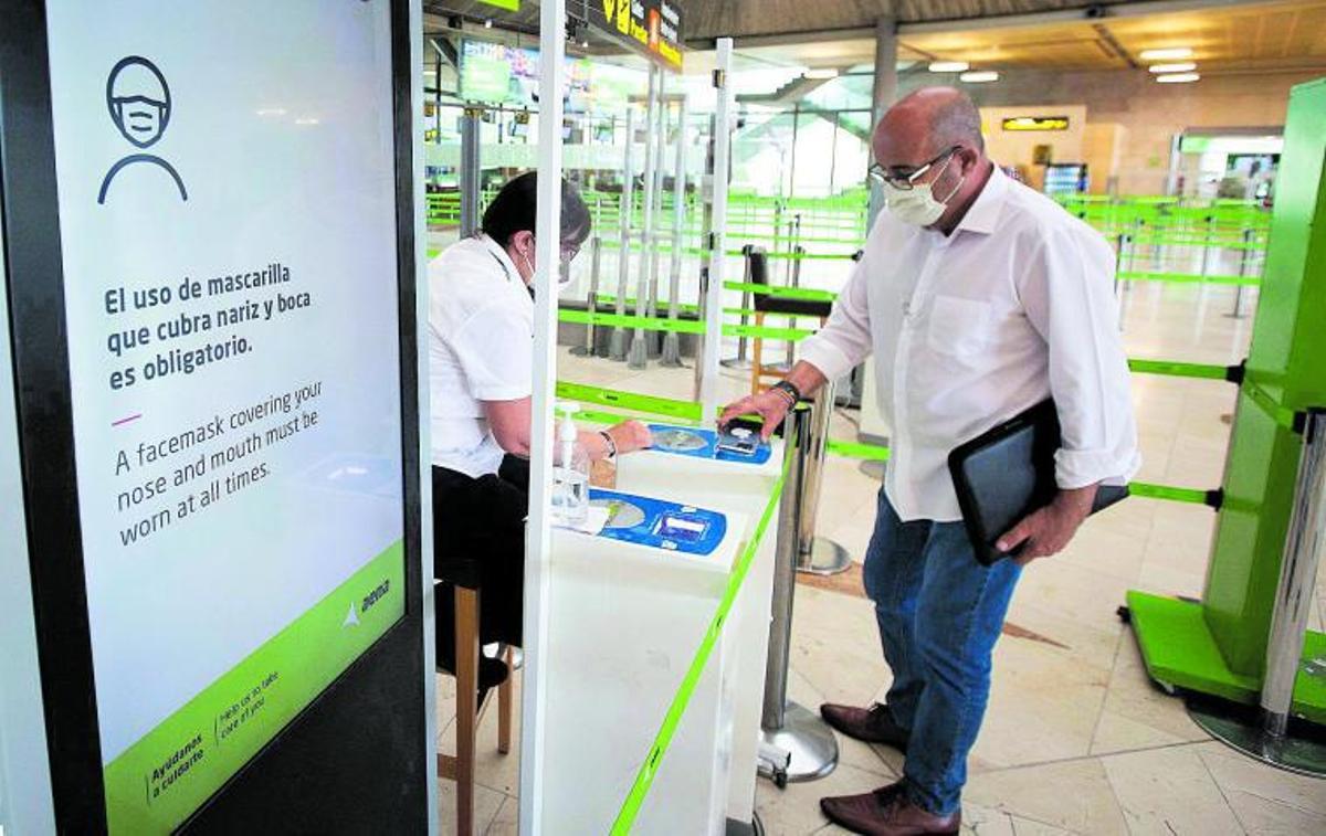 Un hombre escanea el código QR de su tarjeta digital de viaje en un control del aeropuerto de Tenerife Norte.