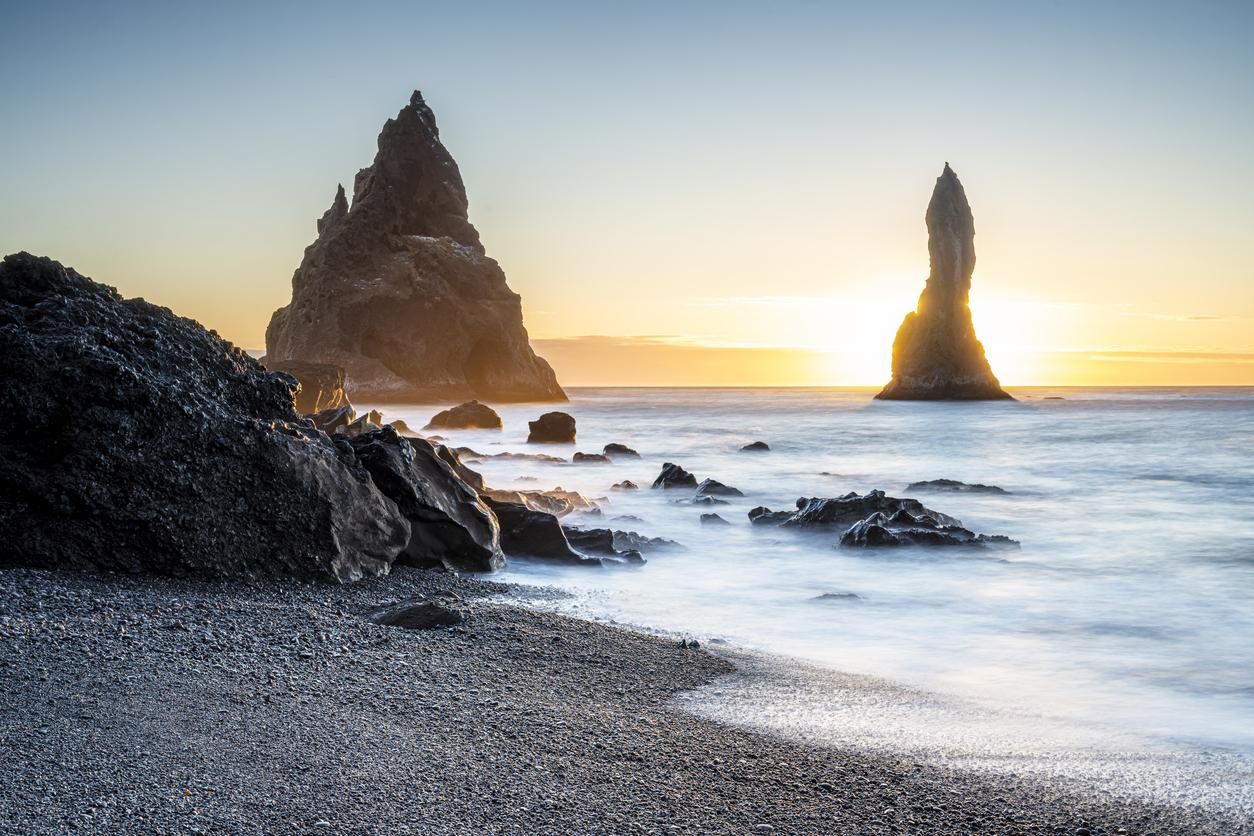 Playa de arena negra de Reynisfjara con afilados promontorios rocosos