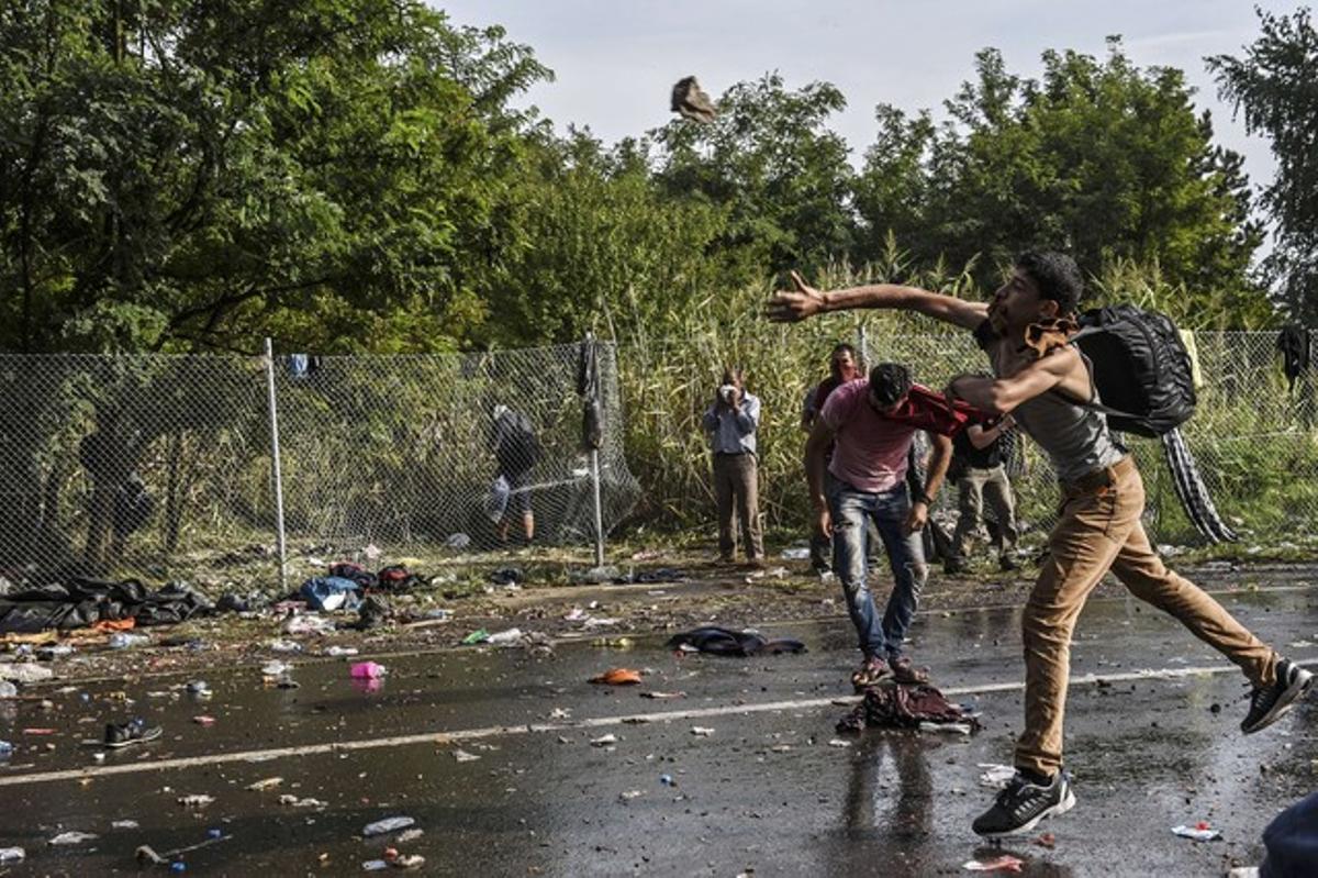 Un refugiado lanza piedras a la policía de Hungría.