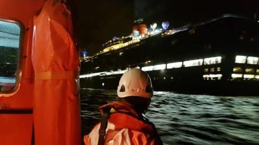 Imágenes de un miembro de Salvamento Marítimo mientras se acercaban al «Queen Elizabeth» y, a la derecha, el crucero de lujo en la bahía de Alicante.