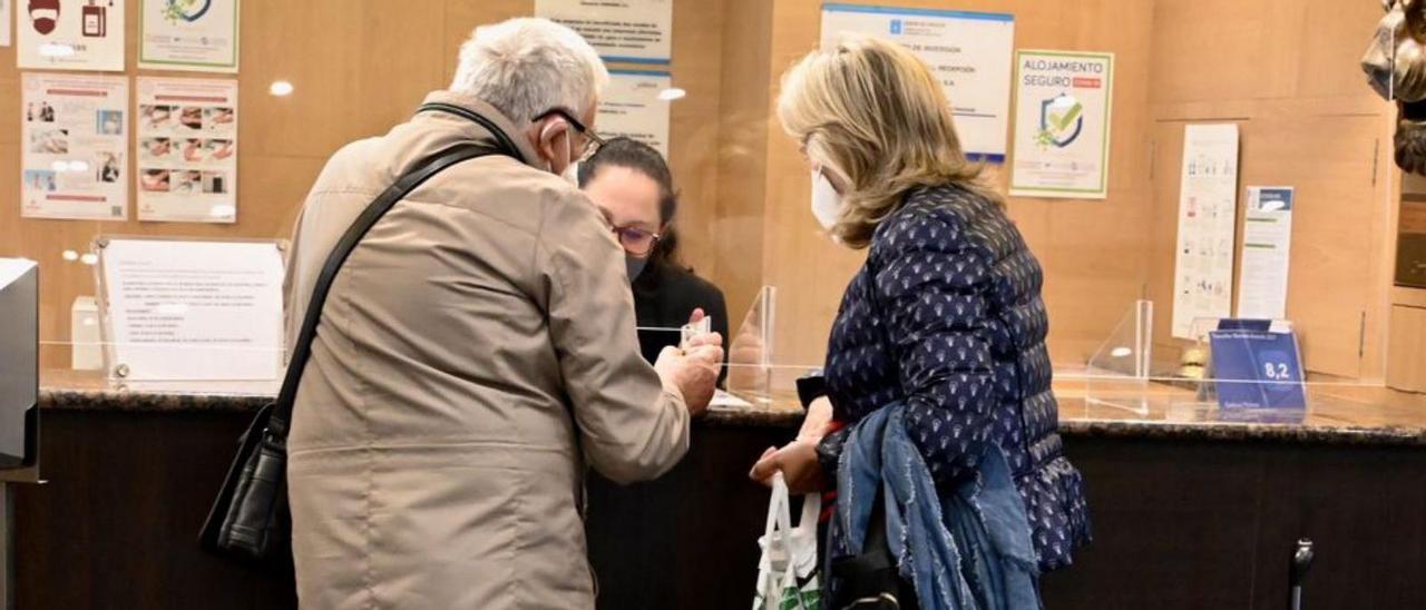 Dos turistas en la recepción de un hotel de Pontevedra.