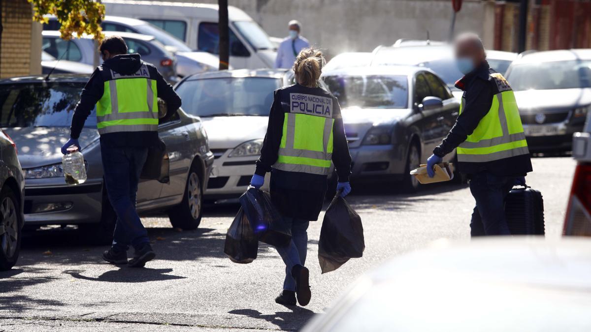 Agentes de la Policía Nacional se llevan la marihuana intervenida en el interior del piso.