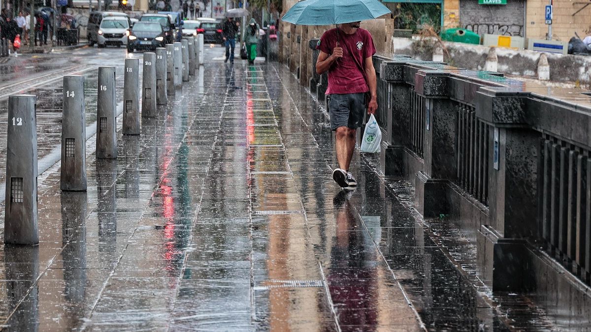 Un hombre camina bajo la lluvia durante la borrasca ‘Garoé’ en Santa Cruz de Tenerife.