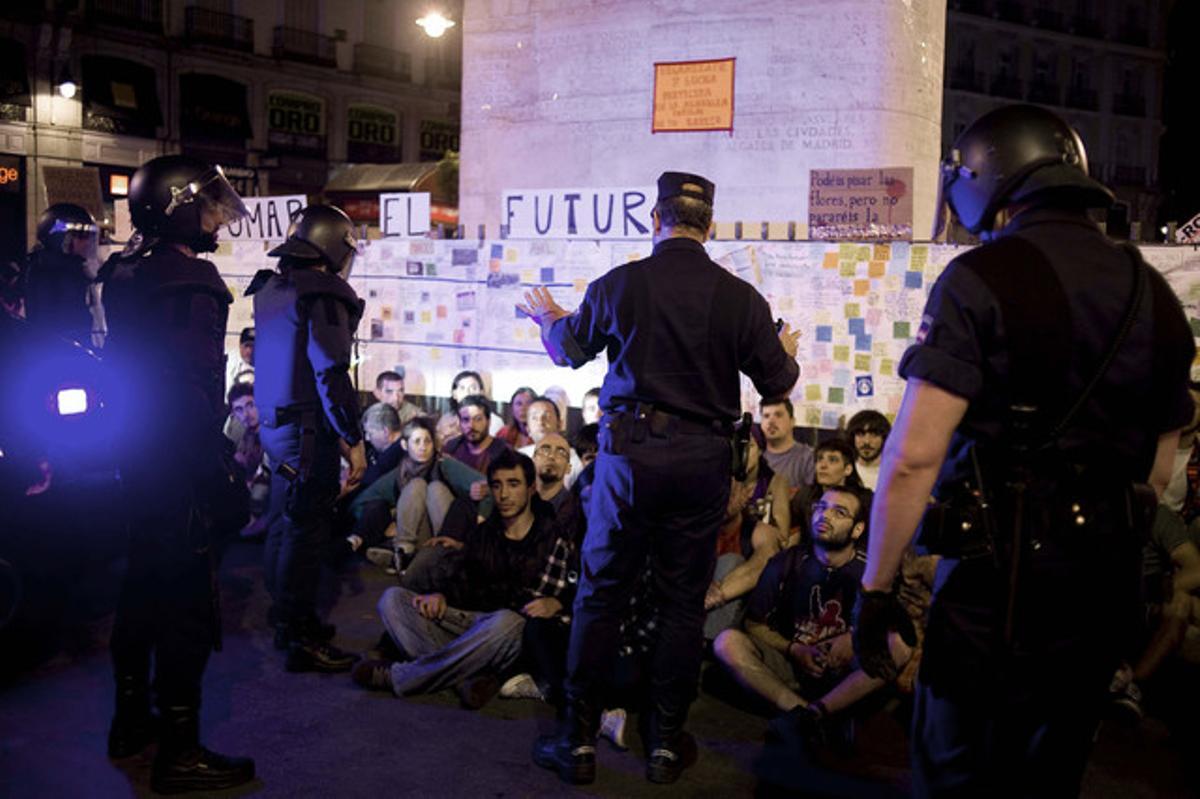 Agents de la Policia Nacional conversen amb els indignats que hi havia a la Puerta del Sol, abans del desallotjament, aquest dilluns. Agents de la Policia Nacional conversen amb els indignats que hi havia a la Puerta del Sol, abans del desallotjament, aquest dilluns.
