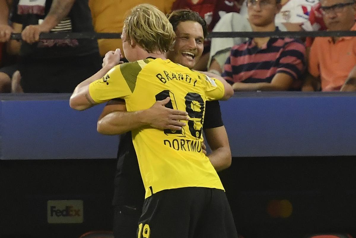 Edin Terzic y Julian Brandt, técnico y jugador del Borussia Dortmund, se abrazan en un partido contra el Sevilla.