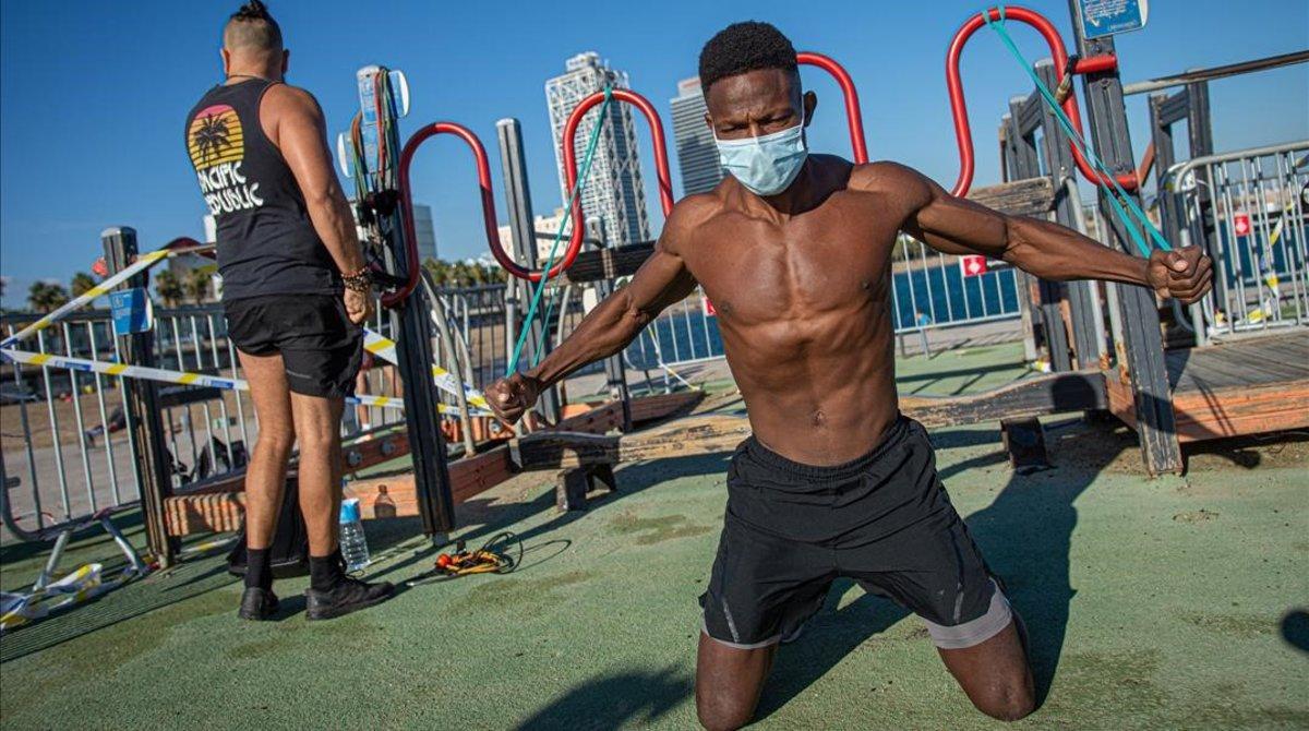 Dos jóvenes haciendo deporte en la Barceloneta. 