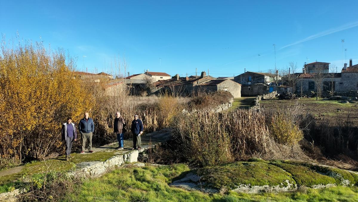 Vecinos sobre el puente con la maleza asomando desde la rivera