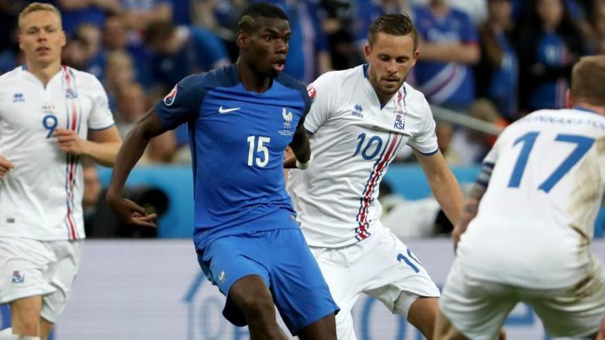 Paul Pogba, autor d&#039;un dels gols del seu equip, controla la pilota entre jugadors de la selecció d&#039;Islàndia.