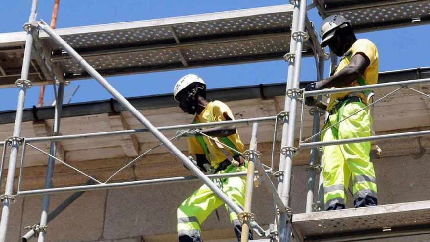 Dos empleados extranjeros trabajan en la construcción de un edificio en Galicia. // Rafa Vázquez