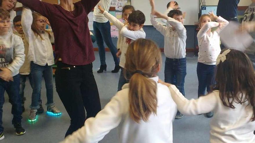 Los escolares bailan con los profesores extranjeros en un aula de la escuela de Vadillo.