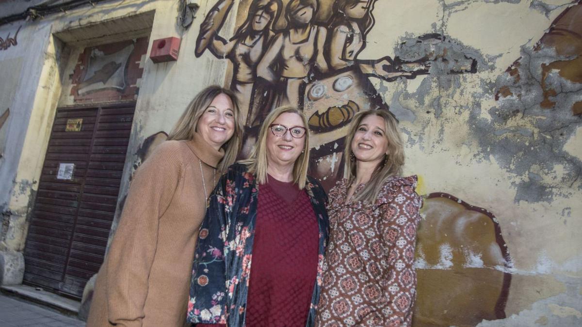 Las tres «Melsicas» delante del grafiti que las representa en la pared lateral del horno. | PILAR CORTÉS