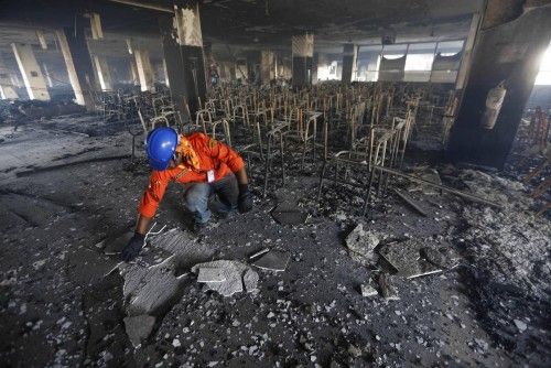 A firefighter inspects the damage at a Standard Group garment factory which was on fire in Gazipur