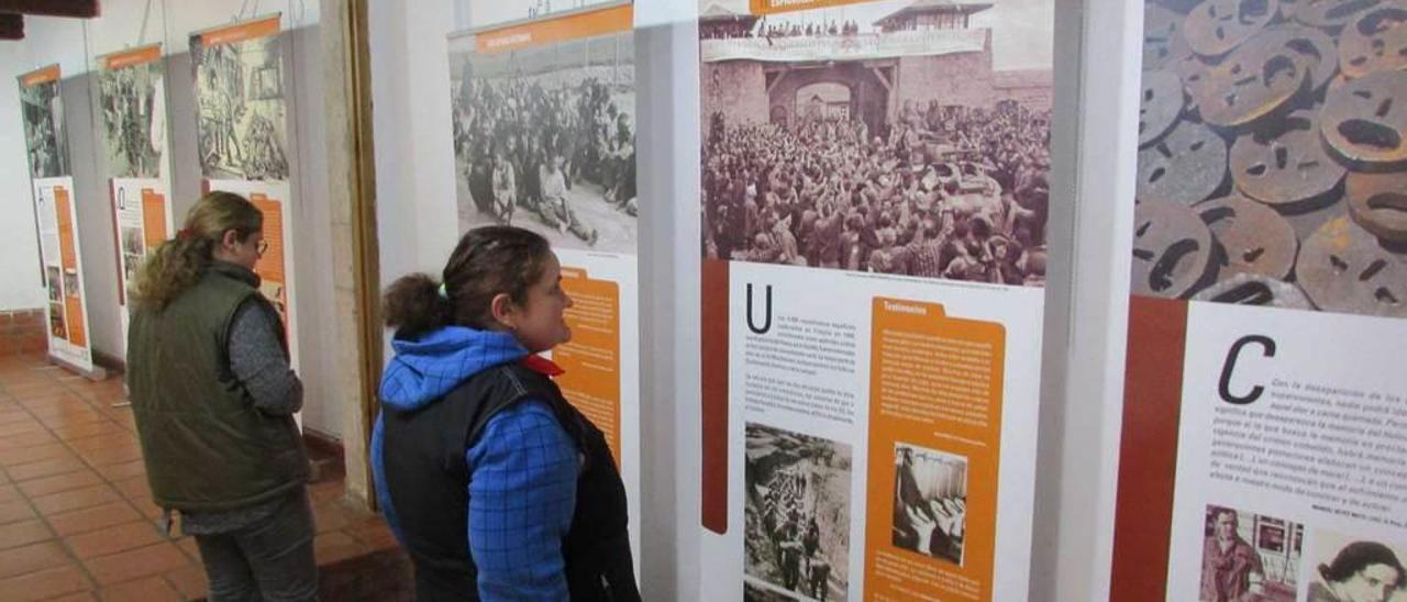 Dos visitantes en la exposición llanisca sobre el Holocausto.