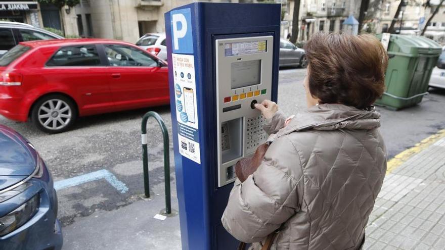 Una mujer pagando el tique de la zona azul en Vigo. // Alba Villar