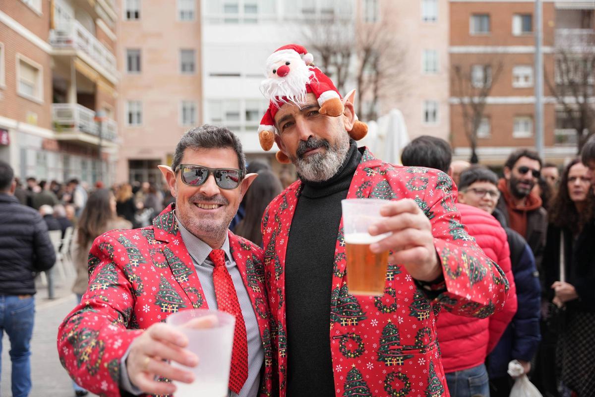 Dos amigos con americanas navideñas disfrutan de la 'tardebuena' en la plaza de los Alféreces de Badajoz.