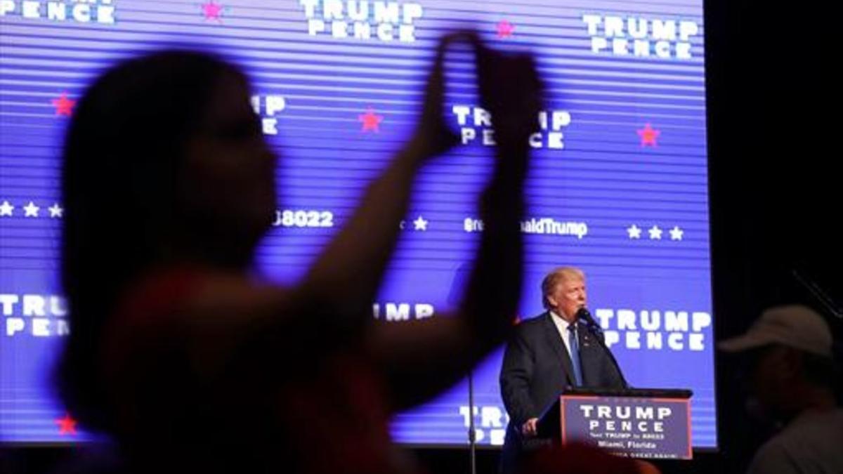 Una electora de Trump se hace una foto para las redes sociales, durante un mitin en Miami.