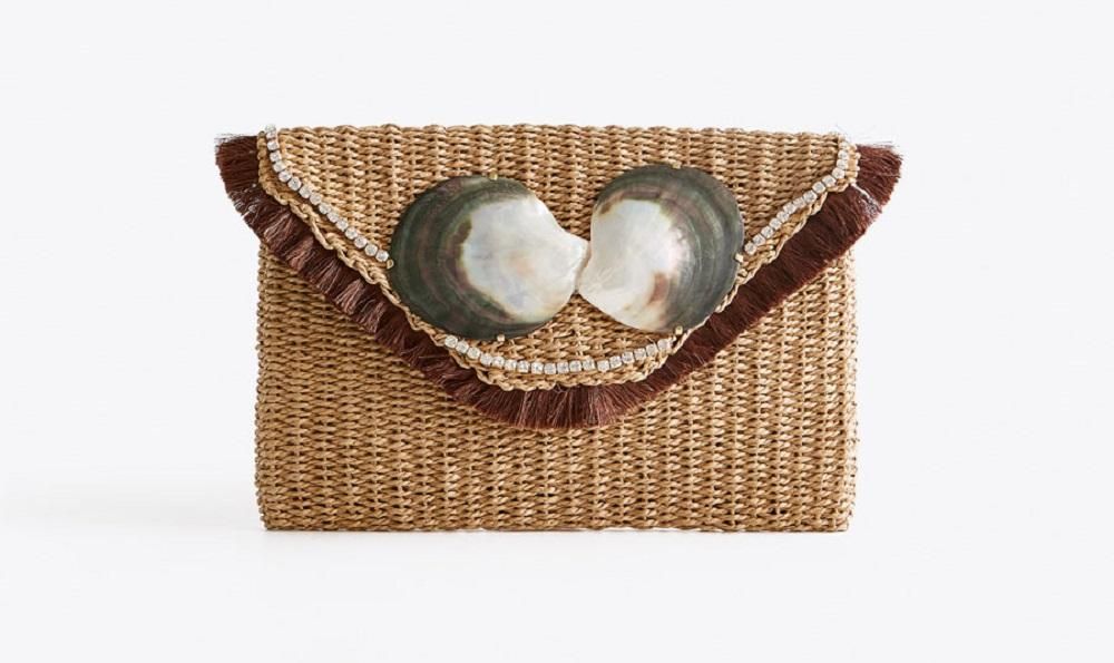 El bolso sobre de rafia con conchas, de Uterqüe