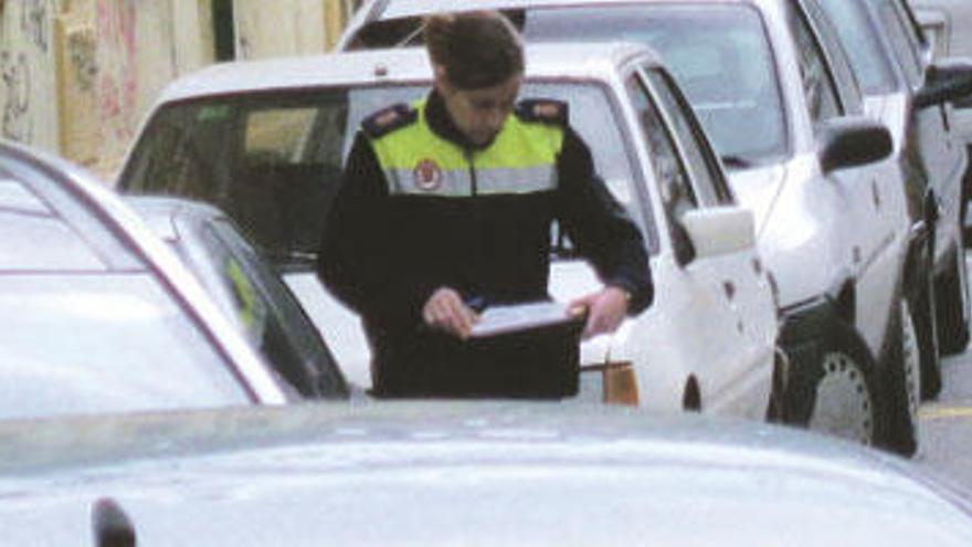 Agentes de la Policía local de Gijón sancionando a un vehículo.
