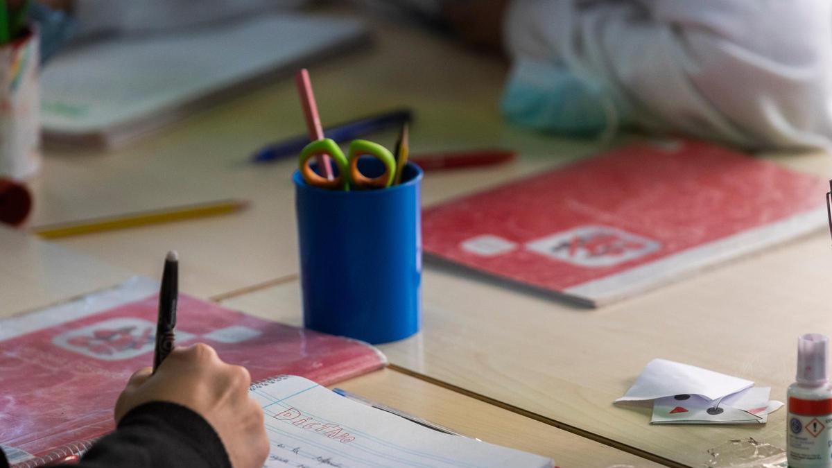 Un escolar escrivint a mà a l'aula