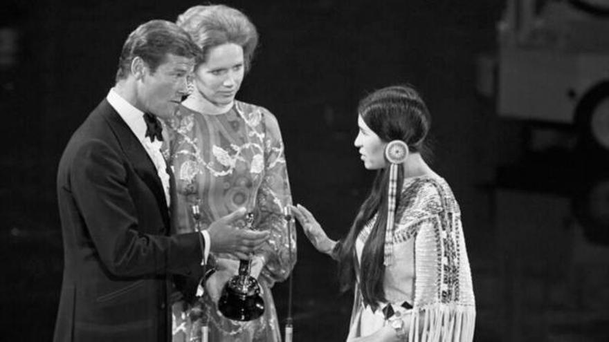 tres noms per a la història dels premis de Hollywood. 1 Sacheen Littlefeather rebutja l’Oscar per a Marlon Brando que li volia lliurar Roger Moore, en la cerimònia del 1973, en presència de Liv Ullmann. |