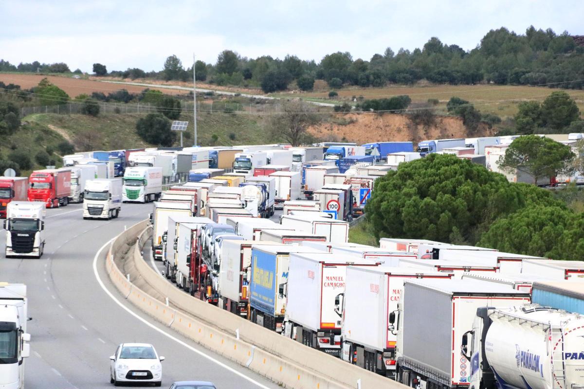Imatge d'arxiu de camions aparcats en sentit sud i la cua dels que volen anar en sentit nord a l'AP-7 a Figueres.