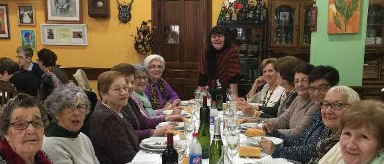 La psicóloga Carolina Carmona, al fondo, junto a algunas de sus alumnas del taller de memoria, durante la comida en Infiesto.