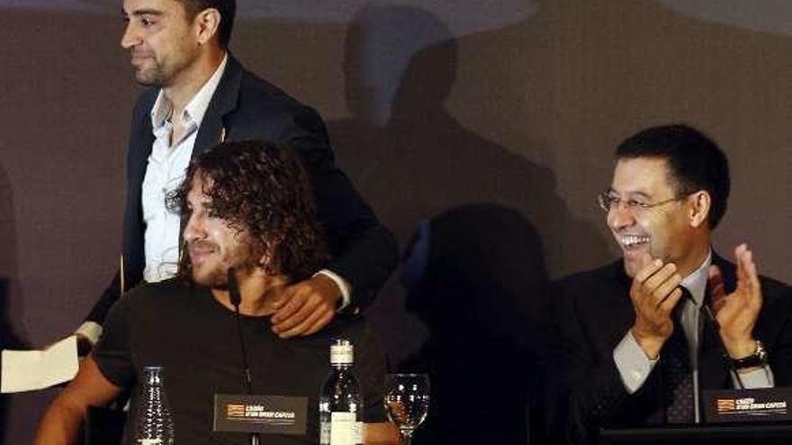 Xavi, detrás de Puyol y Bartomeu, en su despedida del Barça.