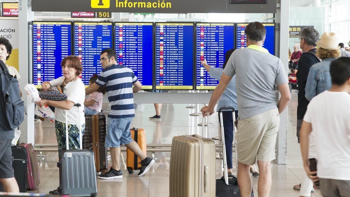 Pasajeros esperando en el aeropuerto de El Prat este martes, donde seguían las colas para pasar el control de seguridad.