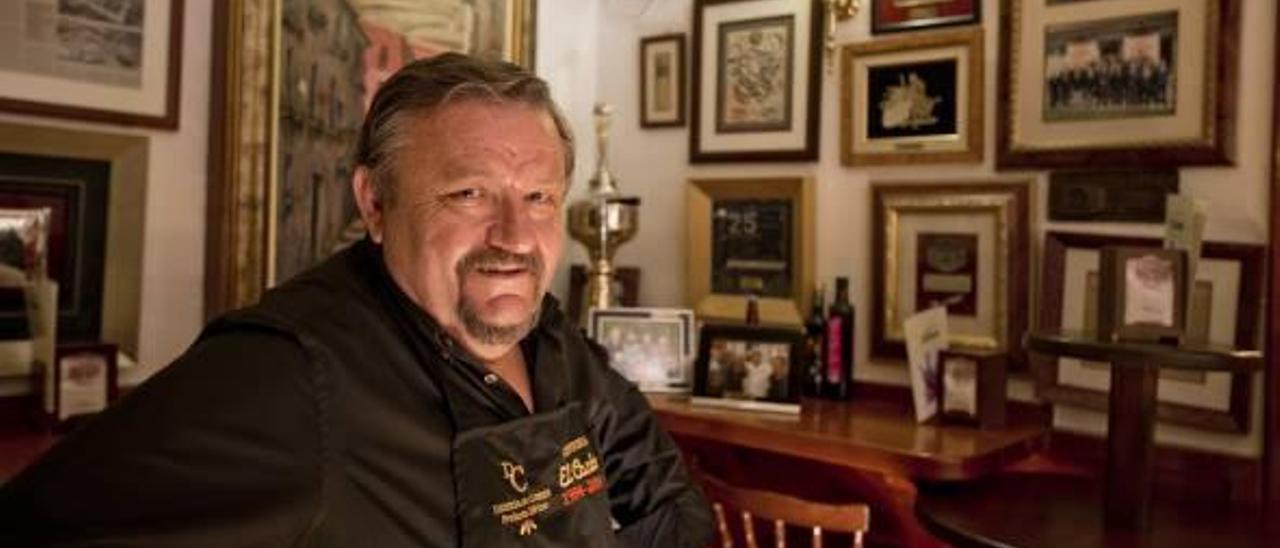 Miguel García, en su restaurante, con las paredes llenas de recuerdos.