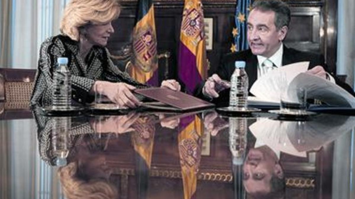 Elena Salgado retira la carpeta del acuerdo, ayer en Madrid, ante la mirada de Bartumeu.