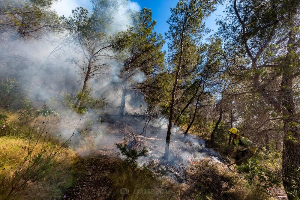 Los bomberos trabajan para sofocar un incendio en el parque de Serra Gelada