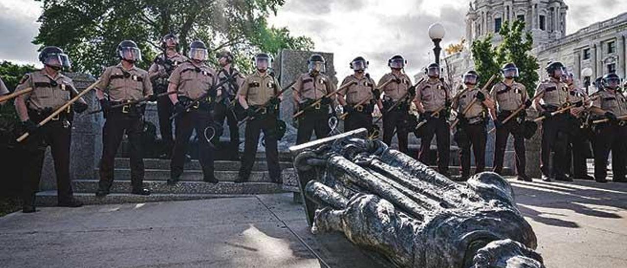 Unos policías, ante la estatua de Colón derribada por unos manifestantes ante el Capitolio del estado de Minnesota (EE UU), en la ciudad de Saint Paul, en junio.