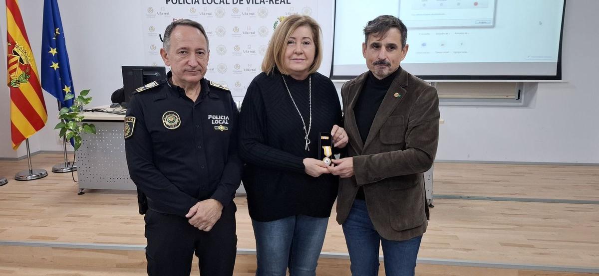 El jeve de la Policía Local, José Ramón Nieto; y el edil de Seguridad, Toni Marín, han entregado a quien fuera inspectora del cuerpo hasta su jubilación, Rosana Gallargo, la Medella de Oro de Mediación Policial.