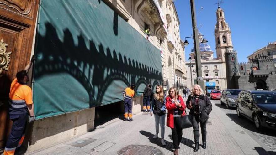 Operarios municipales iniciando el montaje de la tribuna festera de autoridades en la fachada del Ayuntamiento.